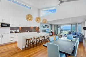 a kitchen and living room with a table and chairs at Costa del Sol - Beachfront Lennox Head in Lennox Head