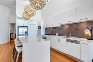 a kitchen with white cabinets and a white counter top at Costa del Sol - Beachfront Lennox Head in Lennox Head