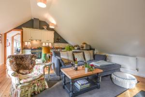 ein Wohnzimmer mit einem Sofa und einem Tisch in der Unterkunft The Linhay in Lydford