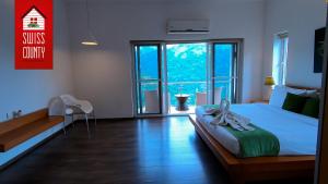 a bedroom with a bed and a large window at SWISS COUNTY in Idukki +35 photos