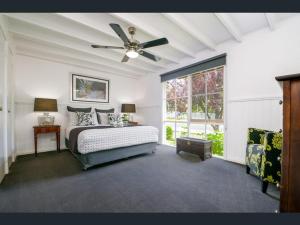 - une chambre avec un lit et un ventilateur de plafond dans l'établissement Creek Cottage Bed and Breakfast Traralgon, à Traralgon