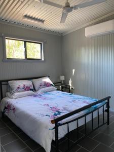 a bedroom with a bed and a window at Corroboree Park Tavern in Marrakai