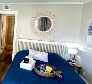 - un lit bleu avec un panier de serviettes et un miroir dans l'établissement Lovely Del Mar retreat private entrance 1 bd 1ba, à San Diego