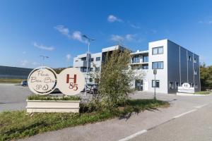 a building with a sign in front of a parking lot at H85 in Chatte