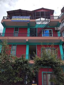 a red building with a sign on it at Harry Guest House & Restaurant in Pokhara