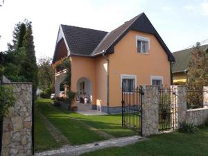 a house with a gate in the yard at Holiday home in Balatonfenyves 18329 in Balatonfenyves