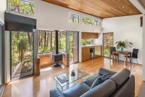 a living room with a couch and a tv at Hidden Valley Forest Retreat in Carbunup