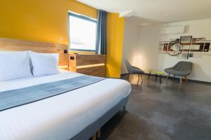 ein Schlafzimmer mit einem großen Bett und einer gelben Wand in der Unterkunft H85 in Chatte