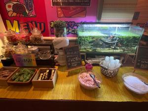 a counter with a fish tank and some food at HOTEL K VILLAGE in Tokorozawa