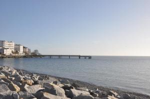 a pier in the middle of the water with rocks at Fürstenhof Sassnitz in Sassnitz