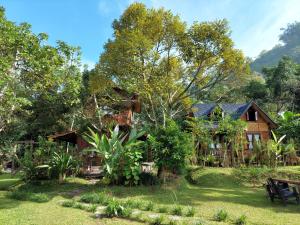 a house in the middle of a yard at Canyon Jungle Stay in Bukittinggi