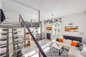 a loft apartment with a staircase and a living room at Victoria Residence by Baltica Apartments in Sopot