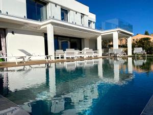 a house with a swimming pool in front of a house at VILLA BLANCHE in Cavalaire-sur-Mer
