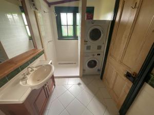 a bathroom with a sink and a washing machine at Kerrellie Cottages 2, 4 & 8 Reid Street in Strahan +18 photos