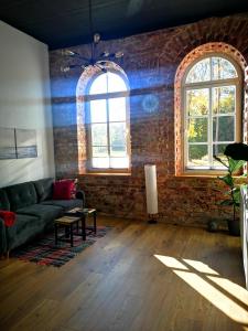 a living room with a couch and a brick wall at Botanical Garden Studio in Kaunas