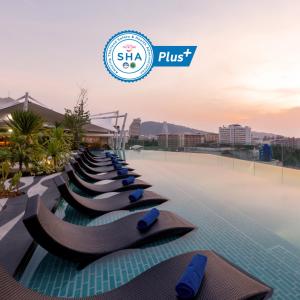 a row of chaise lounges on a pool at a resort at Journeyhub Phuket Patong in Patong Beach