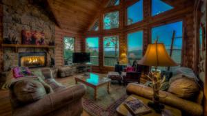 a living room with couches and a fireplace in a log cabin at Plane View in Morganton