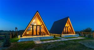 a small house with a triangular roof at night at Green Hill Panoramic in Poiana Mărului