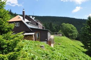 a house on the side of a hill with trees at Penzion U Kotle in Horni Misecky