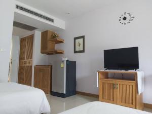 a room with a bed and a television on a stand at Samerdrow Khao Yai in Mu Si