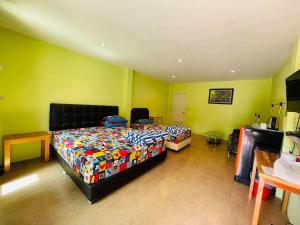 1 dormitorio con 2 camas en una habitación con paredes amarillas en Baan Sri Family, en Kabin Buri