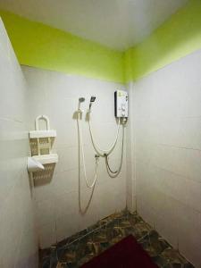 y baño con ducha y paredes verdes. en Baan Sri Family, en Kabin Buri