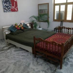 a bedroom with a large bed and two chairs at La Casa Art Stay in Udaipur