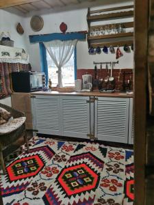 een keuken met een tapijt op de vloer bij Complex Tradițional Casa din Vale Breb in Breb