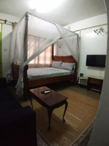 a living room with a bed and a table at SAFI Apartment in Mombasa