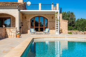 ein Haus mit einem Pool und einer Terrasse in der Unterkunft Finca Can Simonet in Santanyi
