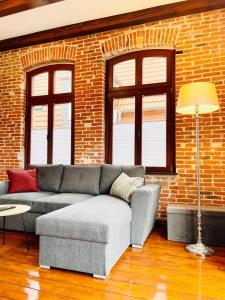 a living room with a couch and a brick wall at Ferienwohnung Greta in Norden