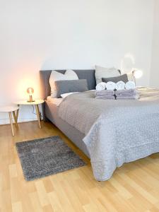 - une chambre avec un grand lit et du parquet dans l'établissement Ferienwohnung Greta, à Norden