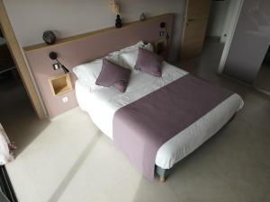 a bedroom with a large bed with purple pillows at VILLA BLANCHE in Cavalaire-sur-Mer +17 photos