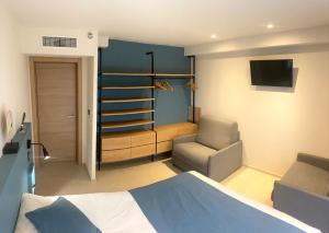 a bedroom with a bed and a chair and a television at VILLA BLANCHE in Cavalaire-sur-Mer