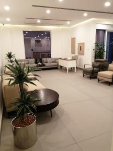 a lobby with a waiting room with couches and a plant at JOOD RESIDENCE in Seef