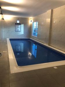 a large swimming pool in a building at JOOD RESIDENCE in Seef