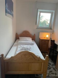 a wooden bed in a bedroom with a window at Lippborger-Hof in Lippetal