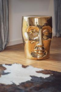 a glass with a face on it sitting on a wooden floor at Prime Park Penthouse Aschaffenburg in Aschaffenburg