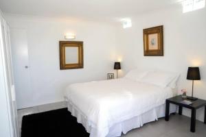 a white bedroom with a bed and a table at Clouds Silver Lining in Beechmont