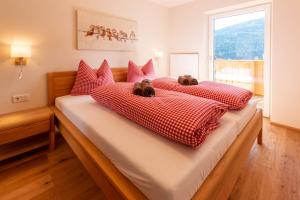 1 dormitorio con 2 camas y almohadas rojas y blancas en Gästehaus Schwaiger en Sankt Michael im Lungau