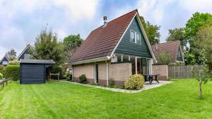 a house with a green roof and a yard at Bungalow 40 op Recreatiepark De Wielen in Sint Maarten +33 photos