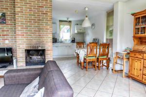 a living room with a couch and a fireplace at Bungalow 40 op Recreatiepark De Wielen in Sint Maarten