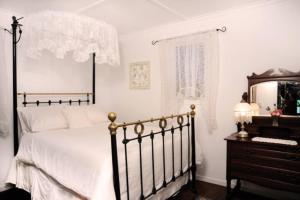 ein Schlafzimmer mit einem Bett, einem Spiegel und einer Kommode in der Unterkunft Old Saint Johns Church in Beechmont