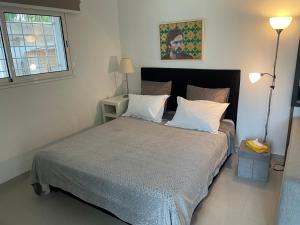 1 dormitorio con 1 cama grande con almohadas blancas en Appartement Studio à Carthage, en Cartago