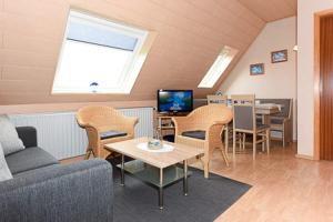 a living room with a couch and chairs and a tv at Ferienwohnung im Haus Fooken in Stedesdorf