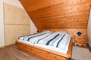 a wooden bed in a room with a wooden ceiling at Ferienwohnung im Haus Fooken in Stedesdorf