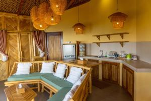 a kitchen with a couch in the middle of a room at Elang Hillside Bamboo Villas in Labuan Bajo