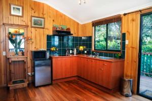 cocina con paredes de madera y suelo de madera en Clouds Chalet, en Beechmont