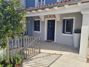 a house with a blue door and a porch at Casa Escarapote in Boiro