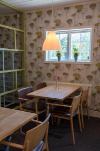 a dining room with a table and chairs and a window at Nätra Motell in Bjästa